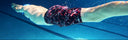 Swimmer's legs in a swimsuit underwater with pool lanes in the background