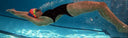Swimmer in a pool wearing a swim cap and goggles, performing a freestyle stroke.