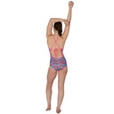 Woman wearing a colorful swimsuit with a pink criss-cross back design on a white background